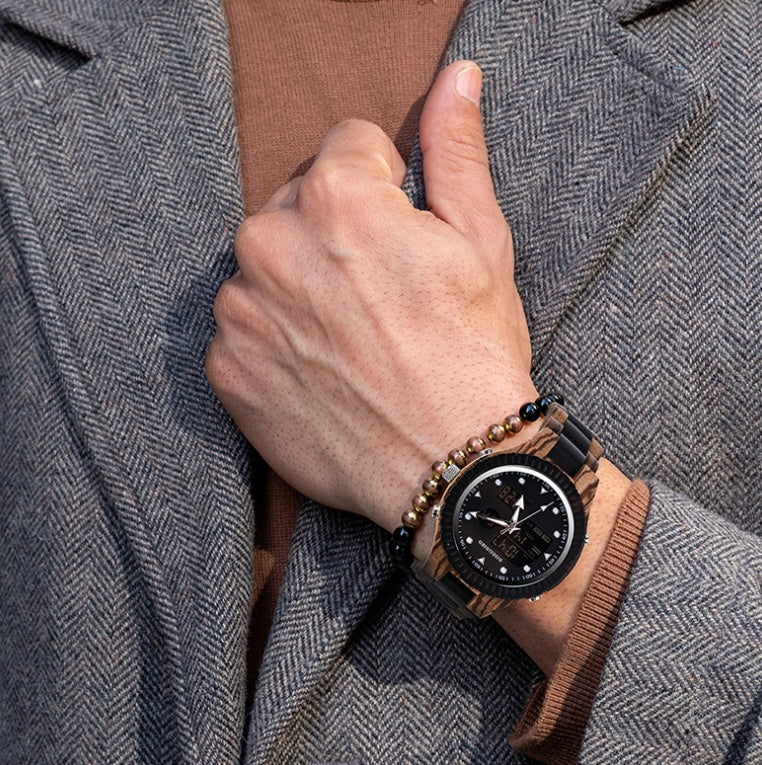 Hand wearing a wooden watch with a detailed face, against a textured gray coat background.