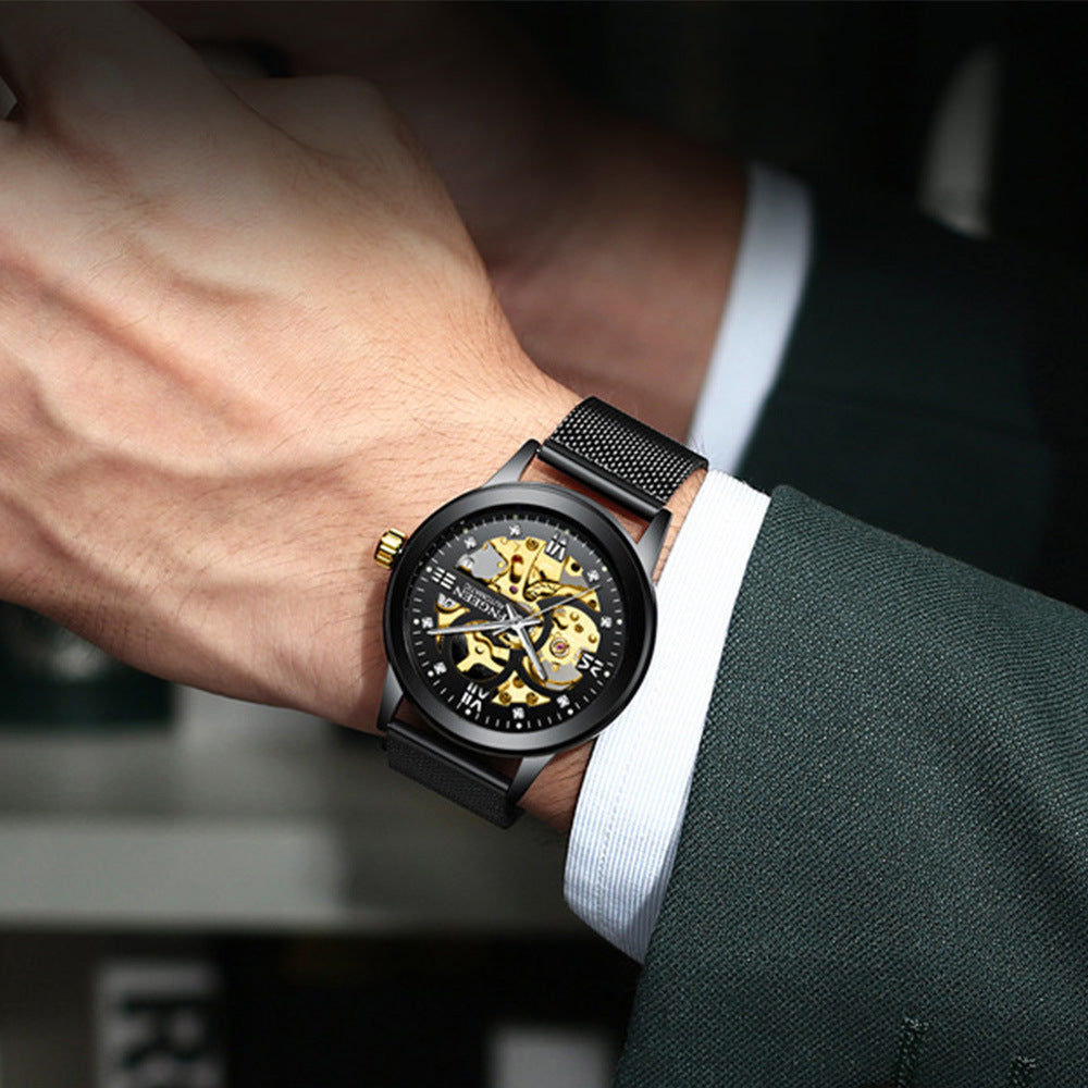 Person wearing a black watch with gold accents on a blurred background