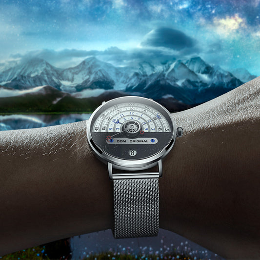 Silver watch on a wrist with a mountainous landscape in the background