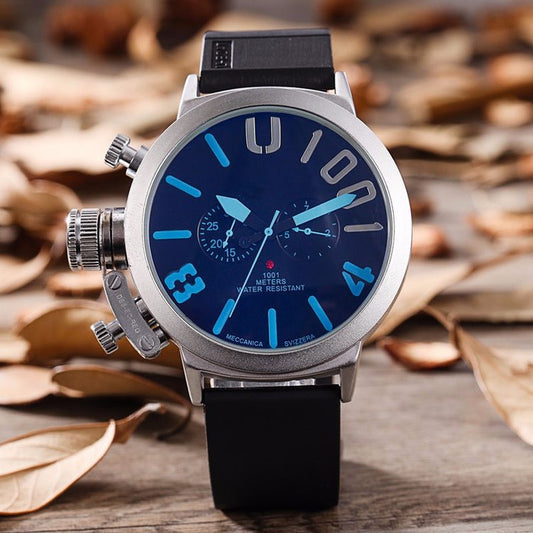 Wristwatch with blue dial and black strap on a wooden surface with leaves