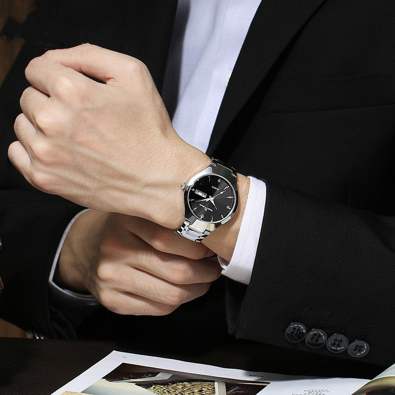 Person wearing a black wristwatch with a suit and white shirt