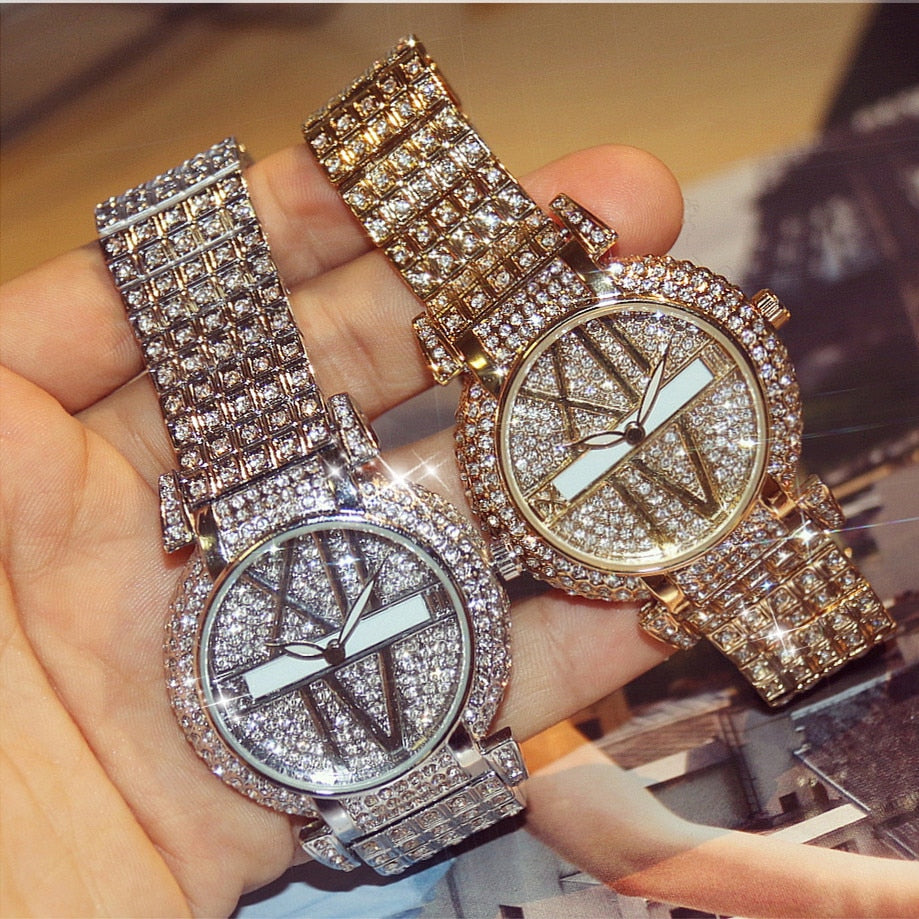 Two ornate watches with diamond-studded bands held in a hand.