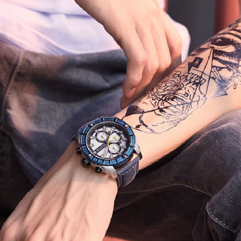 Person wearing a blue wristwatch with a tattooed arm